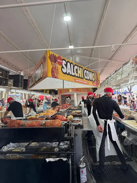 Stand Salchi Cono de La Alemana con el equipo preparando salchichas en la plancha