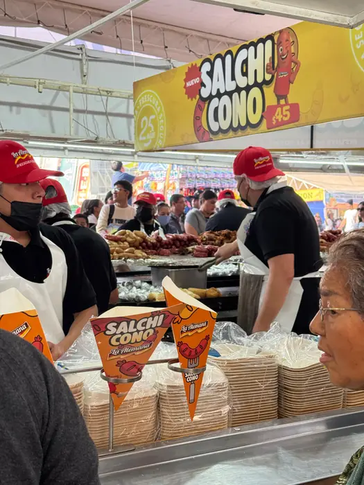 Visitantes recibiendo su Salchi Cono en el mostrador del stand