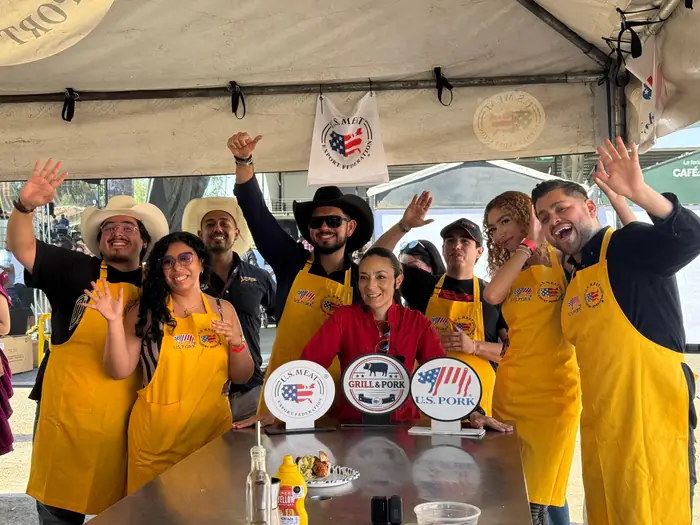 Equipo de parrilleros celebrando con los brazos en alto al terminar la competencia